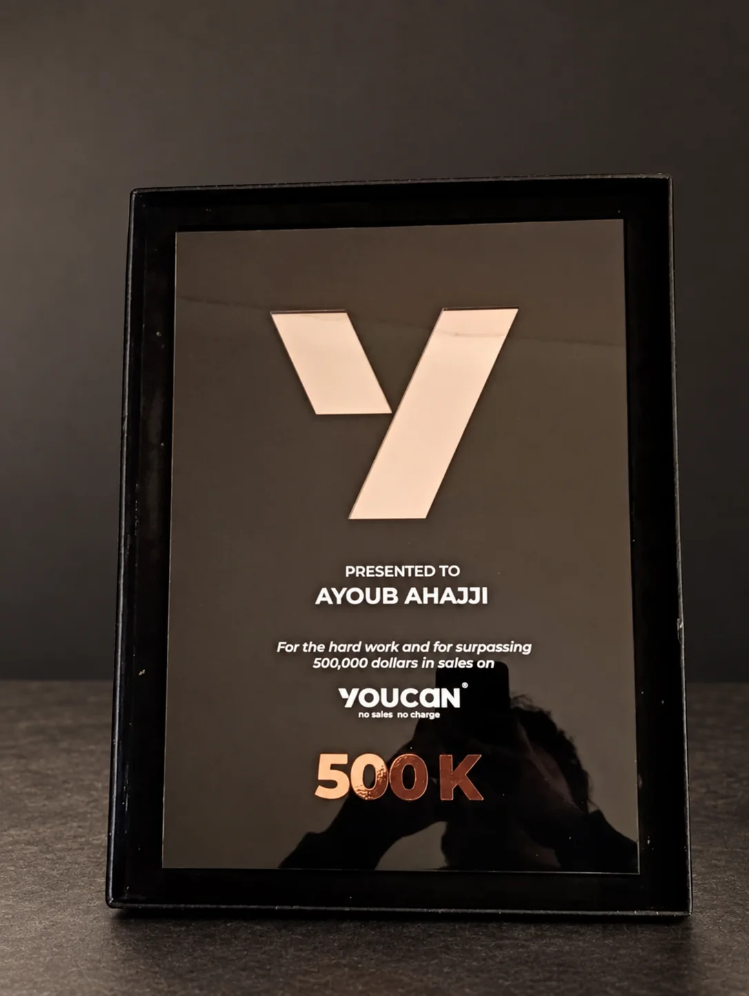Real YouCan 500K sales award on a retouched studio background